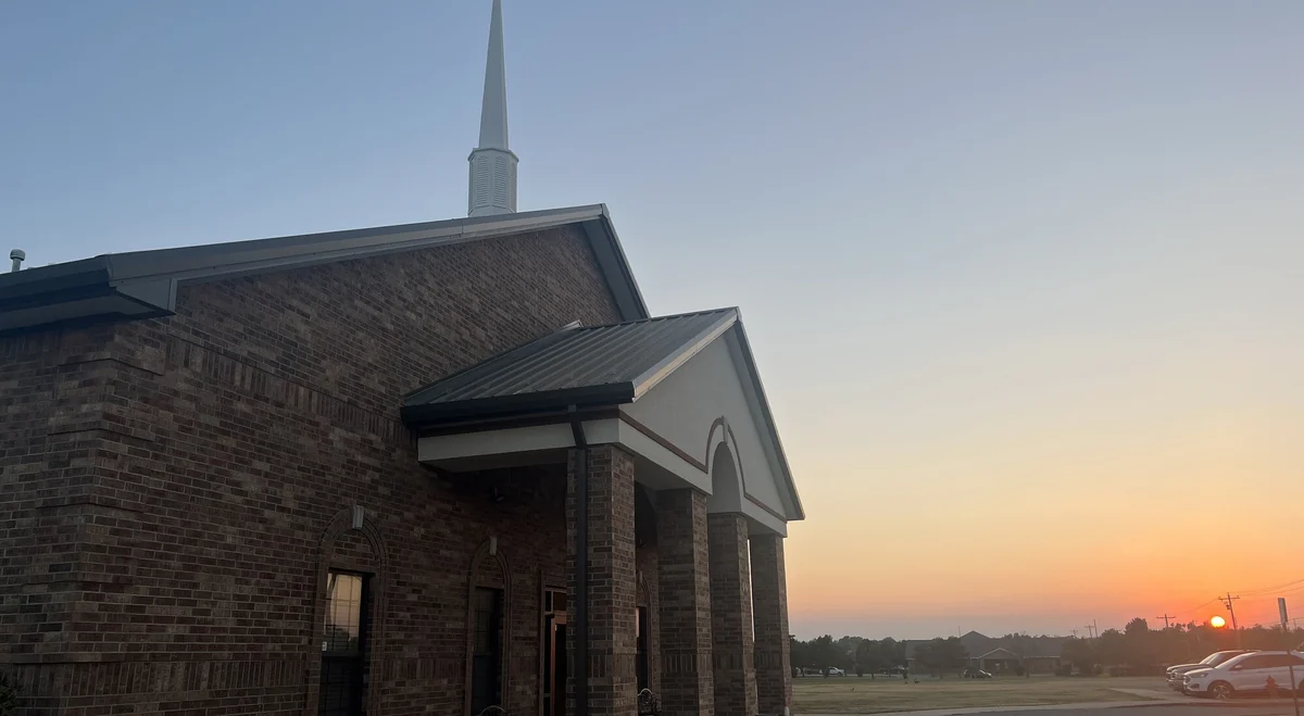 The brick entrance and steeple of New Heights Baptist Church at sunset